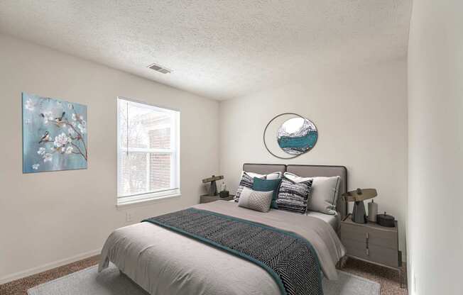 A bedroom with a bed, nightstand, and a painting on the wall.