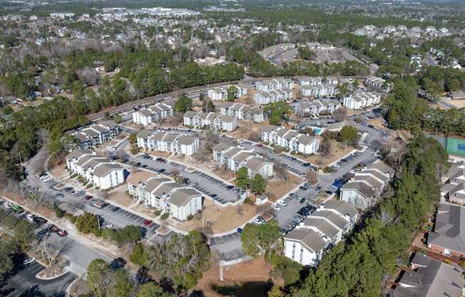 A bird's eye view of a residential area with houses and parked cars.