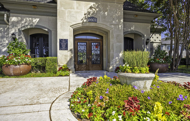 the front door of a house with flowers in front of it