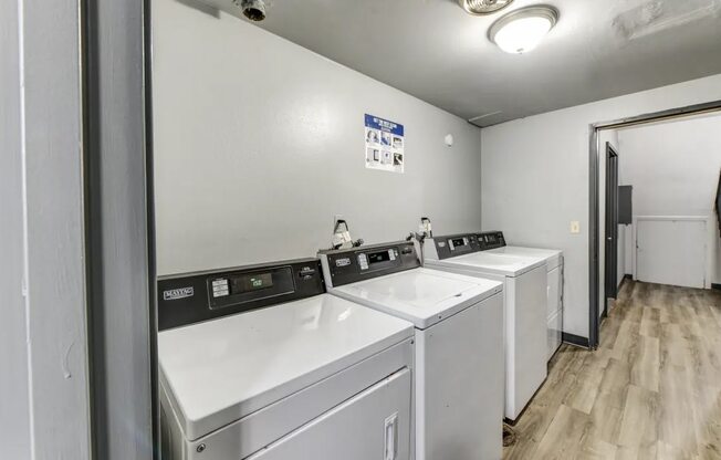 a laundry room with four washers and two dryers