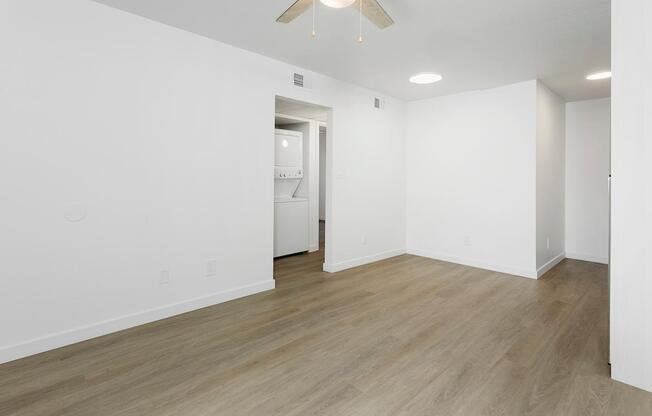 A room with a white wall and a doorway leading to another room.