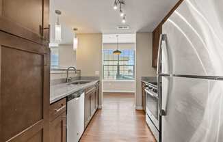 a kitchen with white appliances and a large window