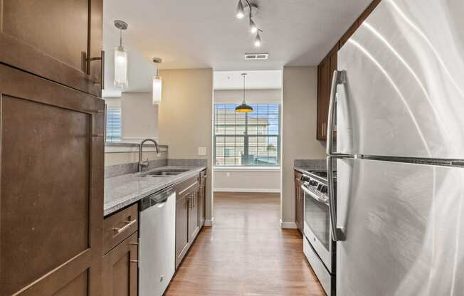 a kitchen with white appliances and a large window