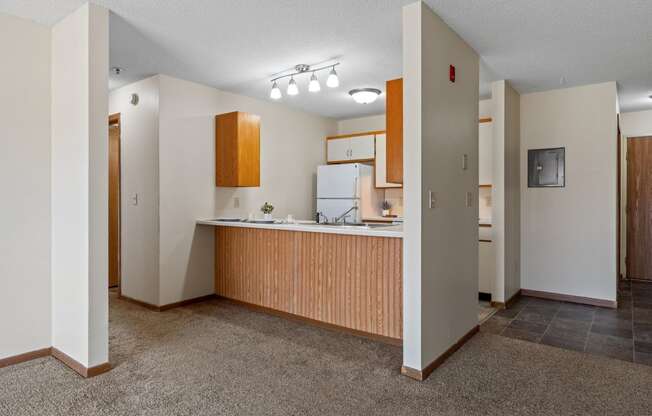 an empty kitchen with a counter top and a refrigerator