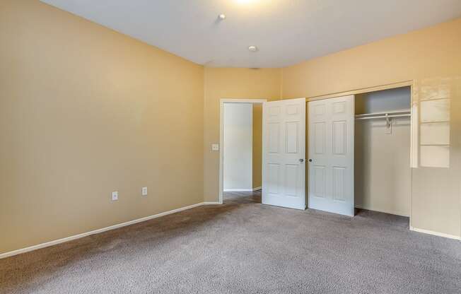 an empty living room with two doors and a closet