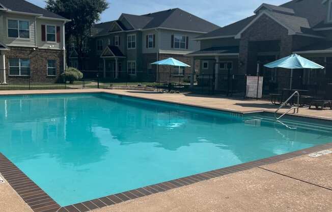 a swimming pool with apartment buildings in the background