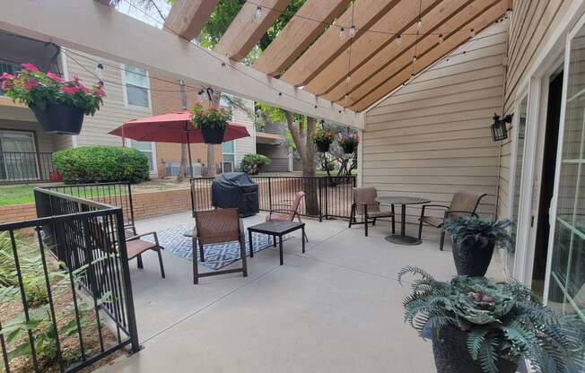 a patio with a pergola and tables and chairs