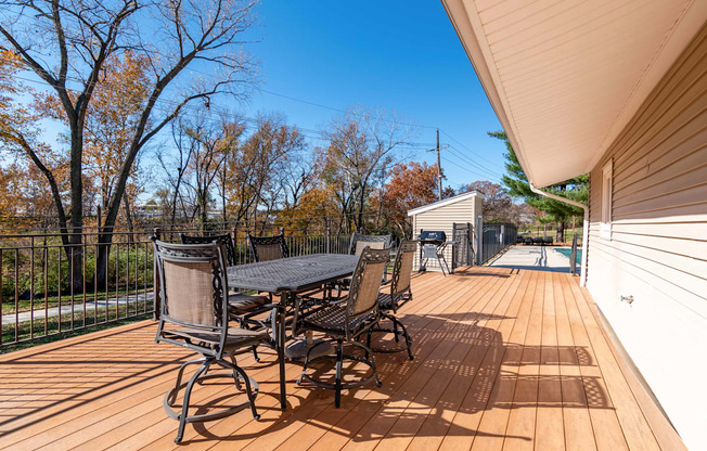 a large deck with a table and chairs and a pool