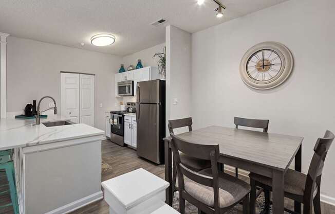 A kitchen with a table and chairs in the middle of the room.