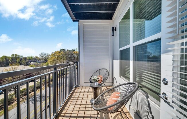 a balcony with two chairs and a view of the ocean