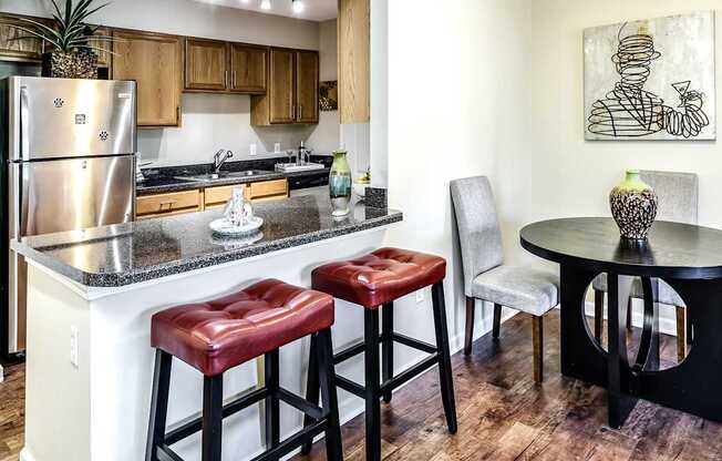 a kitchen with a breakfast bar and stools next to a kitchen counter with a