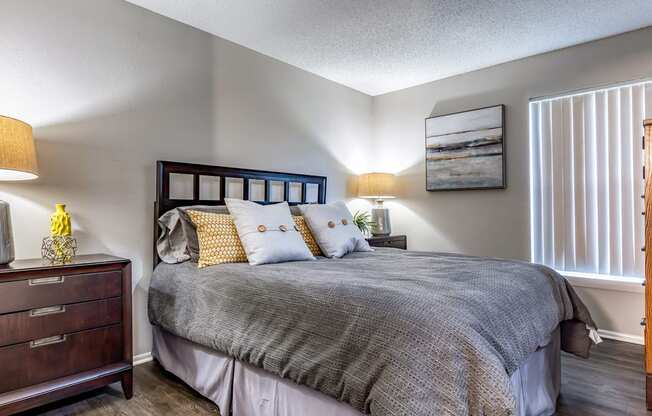 a bedroom with a bed and a dresser and a window