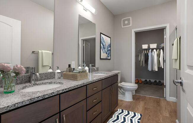 a bathroom with two sinks and a toilet and a mirror