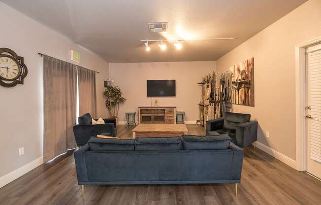 A living room with a dark blue couch and a flat screen TV mounted on the wall at Autumn Oaks Apartments, Roseville, CA, 95678