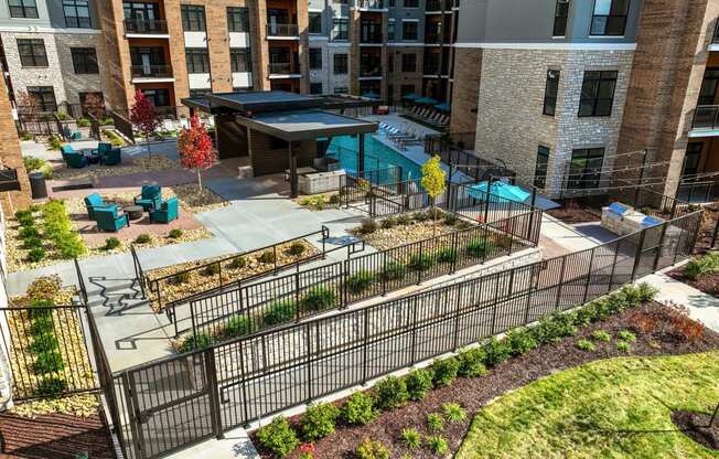an aerial view of a courtyard with a fence and plants in front of a building