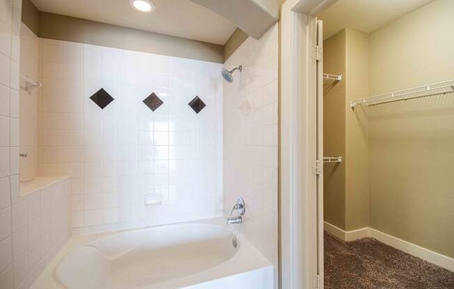 a bathroom with a bathtub and a shower At Metropolitan Apartments in Little Rock, AR