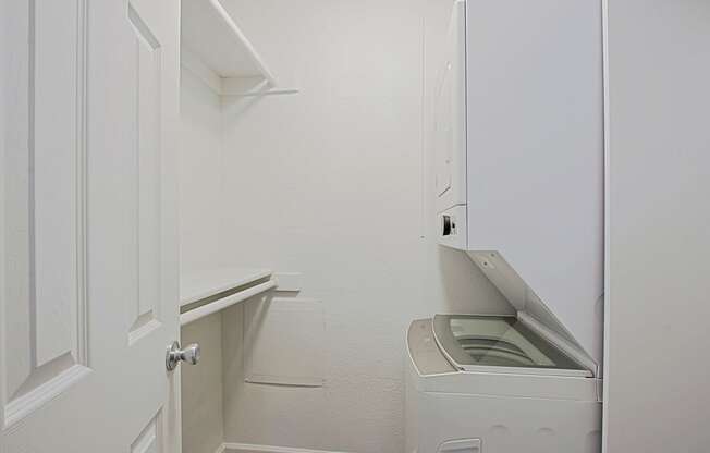 a small laundry room with a washer and dryer and a white door