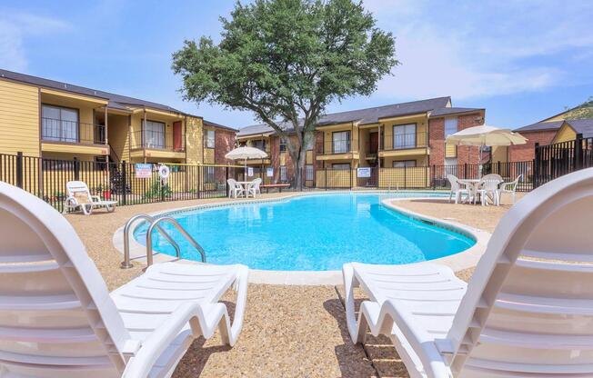 a couple of lawn chairs sitting on top of a swimming pool