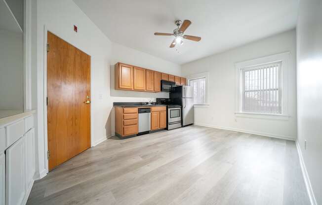 A kitchen with wooden cabinets and a ceiling fan.