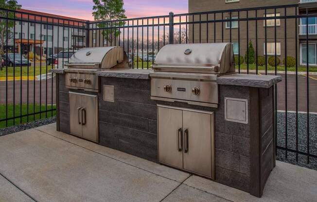 Community grills in a fenced in community space.