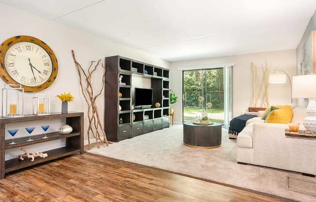 A living room with a large clock on the wall.