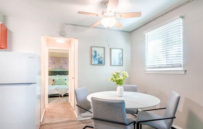 a dining room with a table and chairs and a ceiling fan