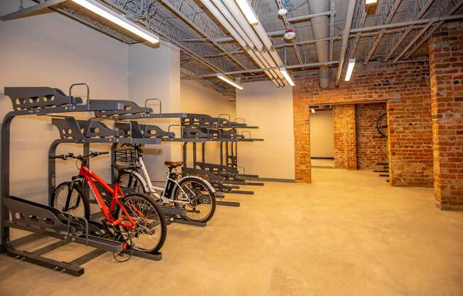 A room with a brick wall and a bike rack.