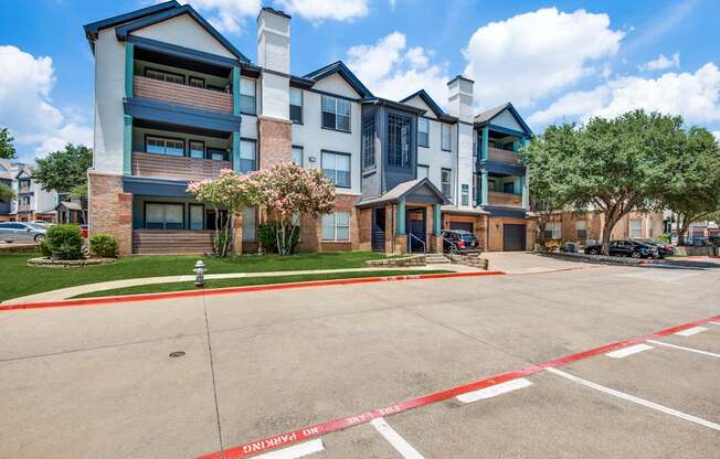 A large apartment complex with a red and white striped barrier in front.