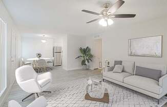 A living room with a white chair and a white couch.