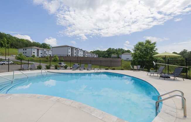 a swimming pool with chairs and a fence around it