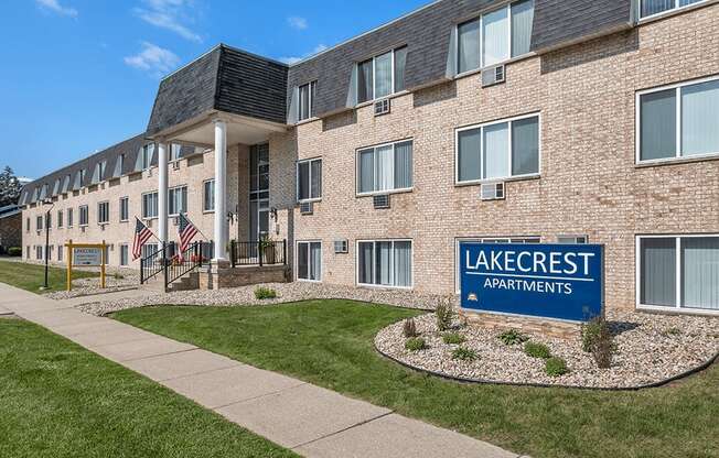 a large brick building with a lake crest apartments sign in front of it