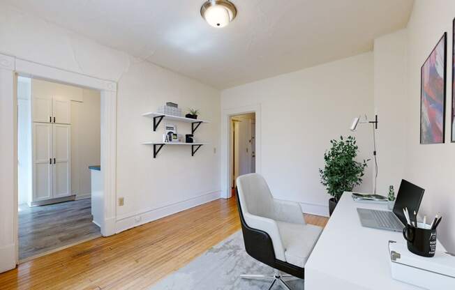 a home office with white walls and hardwood floors