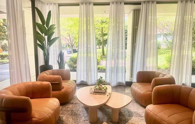 A room with orange chairs and a table with a plant on it.