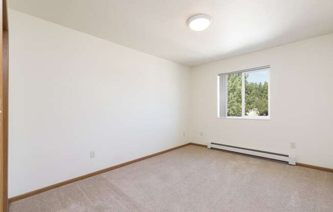 Empty room with carpet and a window at Sunset Ridge Apartments in Bismarck, 58503