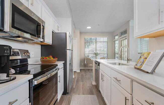 A modern kitchen with white cabinets and a wooden floor. at The Orchard, Dublin, 43016