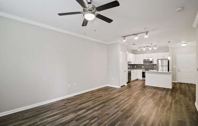 A room with a ceiling fan and wooden flooring.
