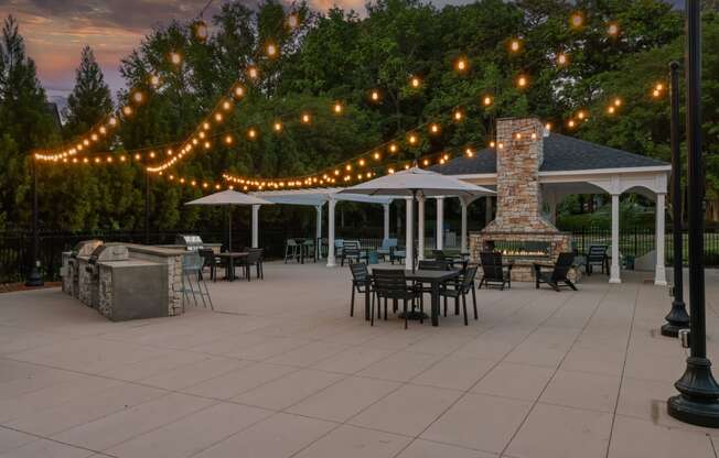 a patio with tables and chairs and strings of lights