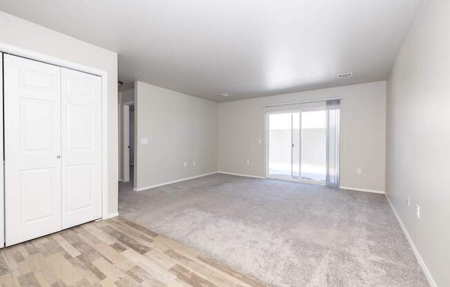 A room with a white door and a carpeted floor.