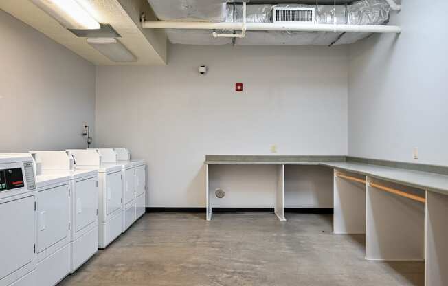 an empty room with washes and dryers in a building