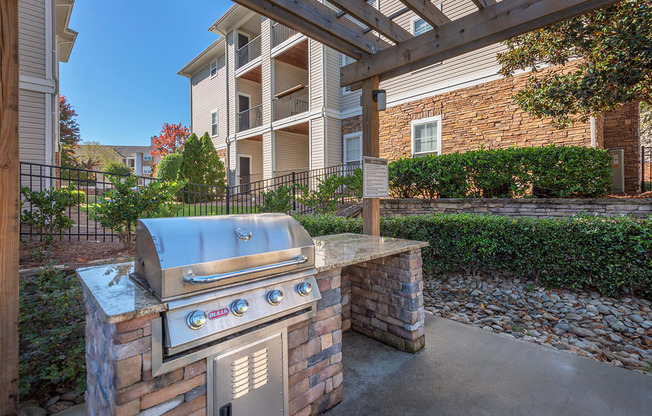 a barbecue grill on a brick wall in front of an apartment building