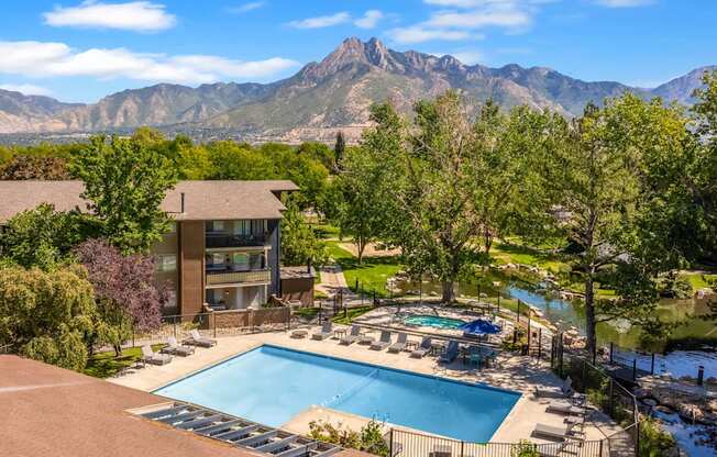 an aerial view of a swimming pool with mountains in the background