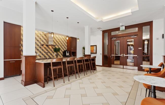 the lobby of a hotel with a bar and tables