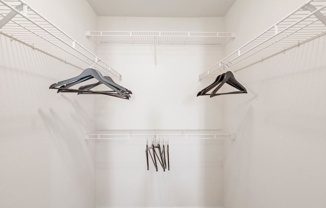 a spacious walk in closet with white walls and a white ceiling