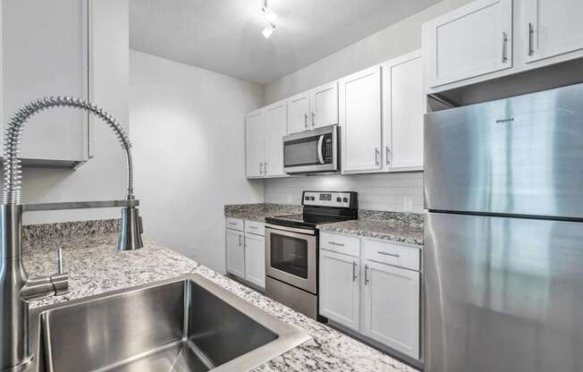 A modern kitchen with stainless steel appliances and white cabinets.