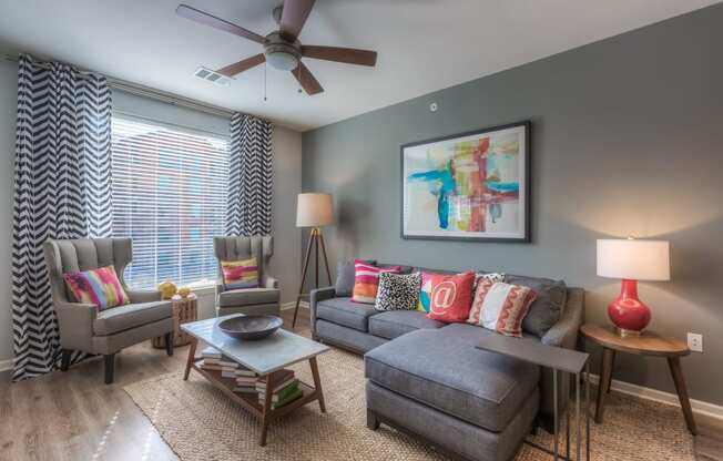 a living room with gray walls and a ceiling fan