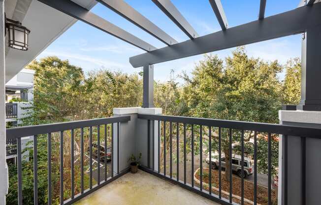 a balcony with a view of a parking lot and trees