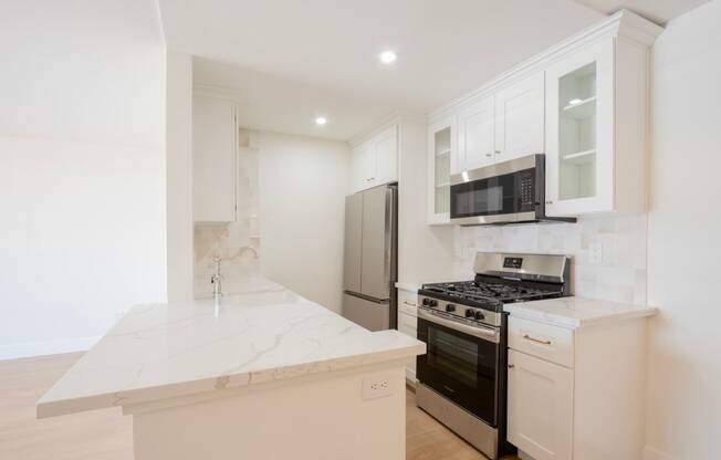 a kitchen with white cabinets and a stove and a refrigerator