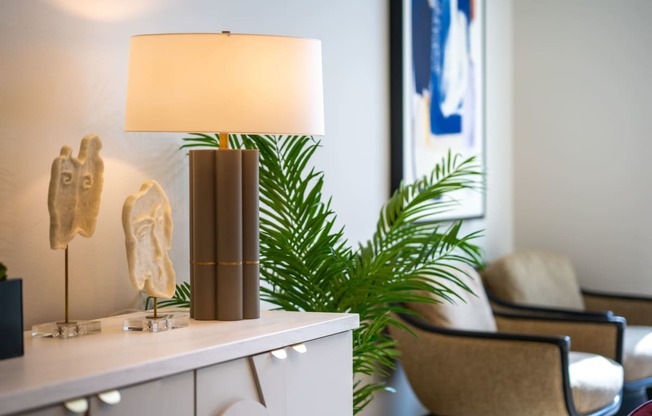 a table with a lamp and a plant in a room