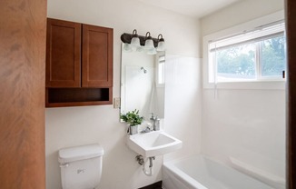 a bathroom with a sink and a toilet and a bath tub. Fargo, ND Luxford Apartments