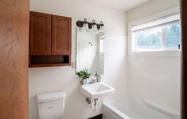 a bathroom with a sink and a toilet and a bath tub. Fargo, ND Luxford Apartments